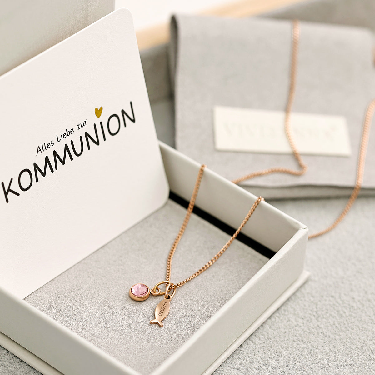 Ichthys Kette mit Geburtsstein – goldener Fisch-Anhänger mit rosa Geburtsstein in offener Kommunion-Geschenkbox