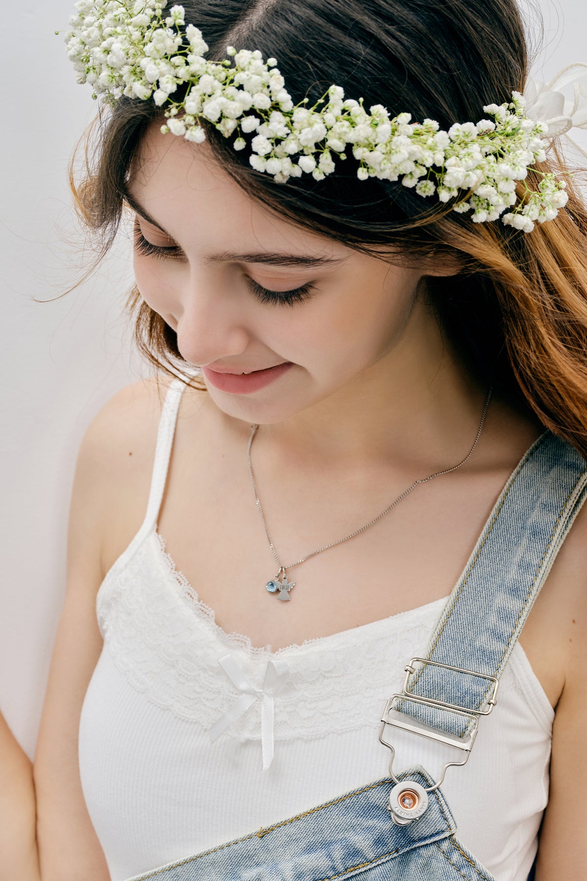 Schutzengel Kette mit Geburtsstein – Mädchen mit Blumenkranz, silberne Engelkette am Ausschnitt sichtbar