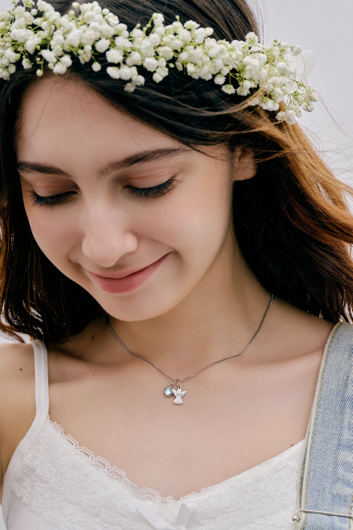 Schutzengel Kette mit Geburtsstein – Nahaufnahme Mädchen mit Blumenkranz trägt silberne Engelkette mit Stein