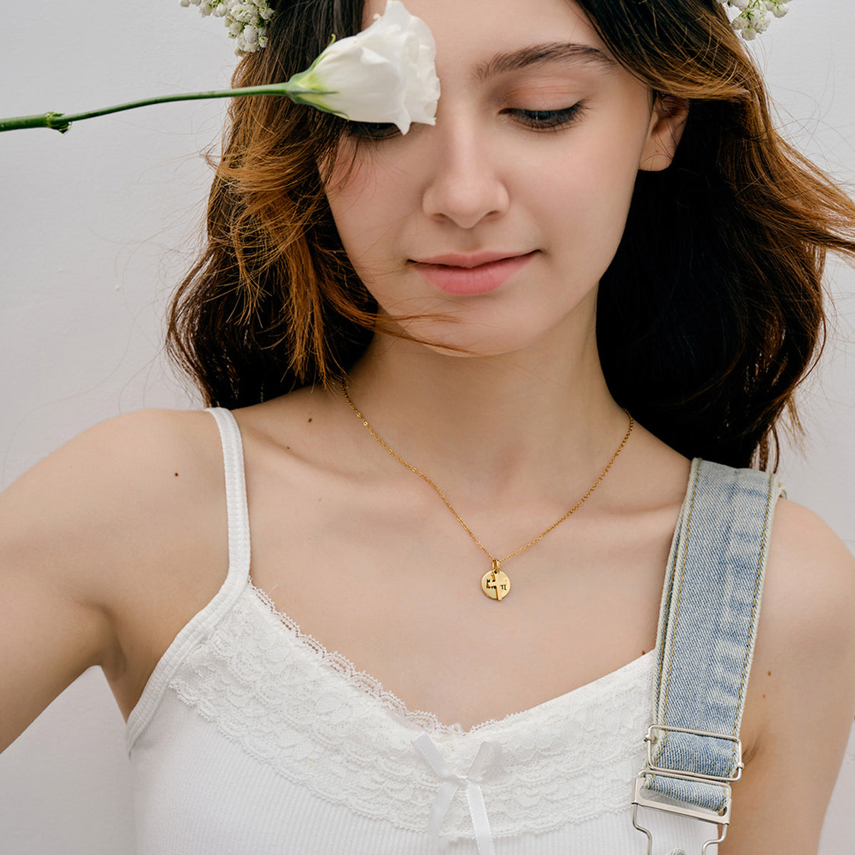 Model mit Blumenkranz trägt Christliche Halskette mit Kreuz & Wunschgravur, Auge mit Blüte verdeckt