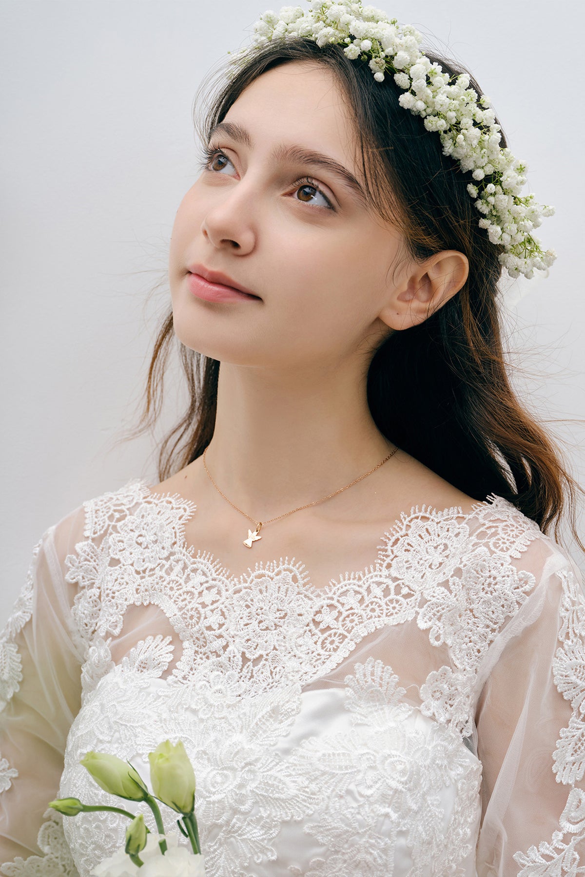 Model mit Blumenkranz und Spitzenkleid trägt Schutzengel-Kette mit Gravur in Roségold