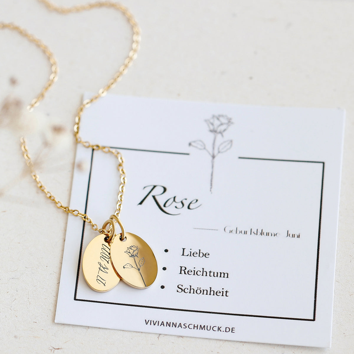 Geburtsblumen Halskette Ovaler Anhänger mit Gravur in Gold – Anhänger mit Rose neben Infokarte zur Geburtsblume Juni