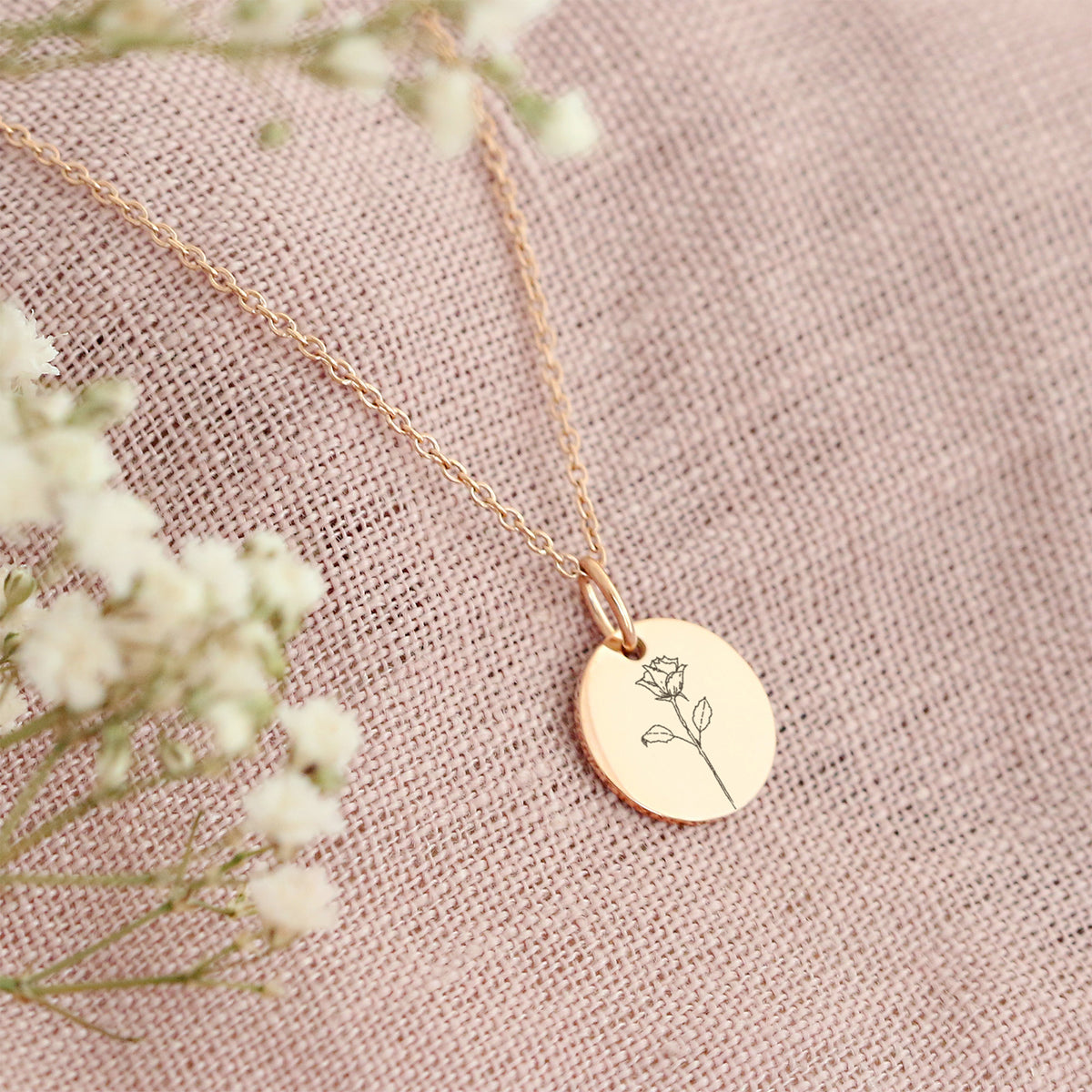 Personalisierte Halskette mit handgezeichneten Geburtsblumen in Gold – Anhänger mit Rosenmotiv auf rosa Leinen