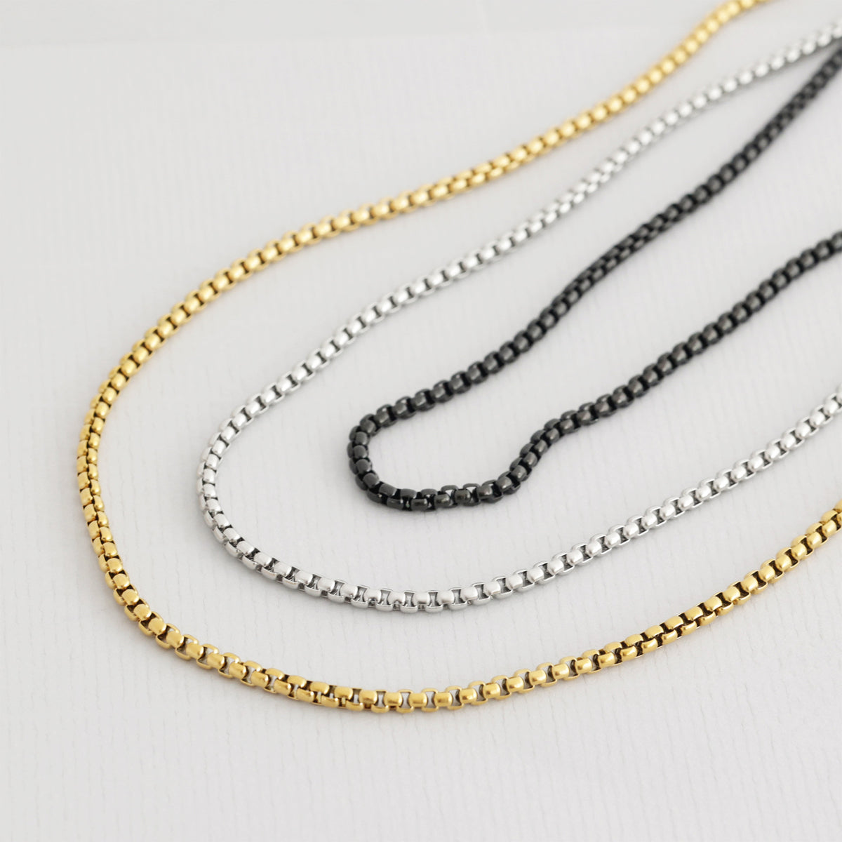 Panzerketten in Gold, Silber und Schwarz nebeneinander in drei Varianten