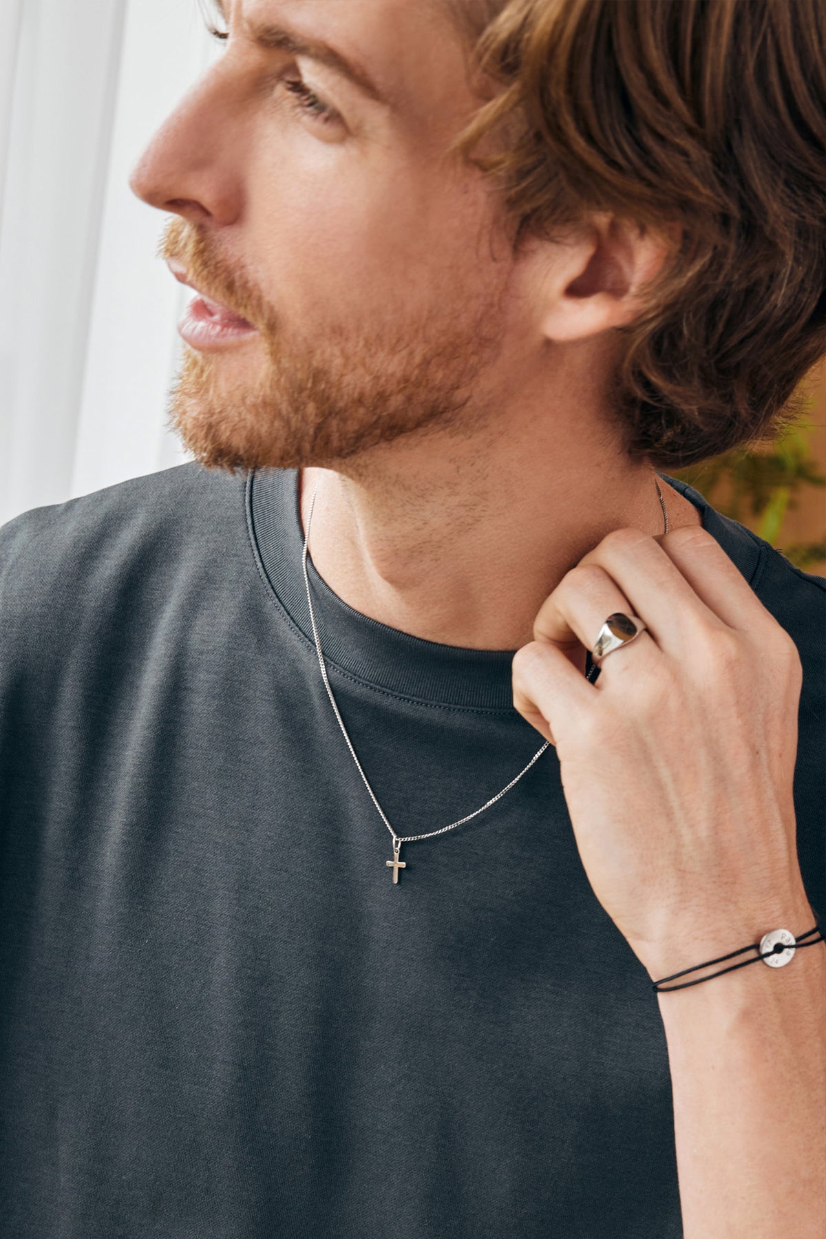 Herren Mini Kreuz Halskette mit Gravur – Mann trägt silberne Kreuzkette und Armband am Handgelenk