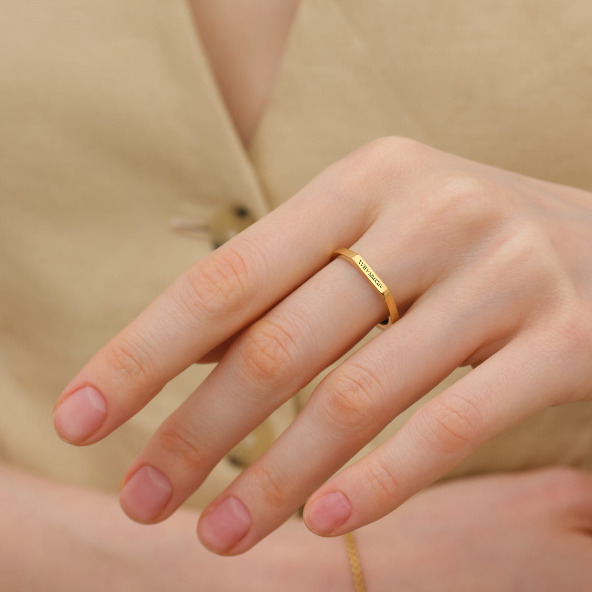 Frau trägt goldenen Geometrischen Stapelring mit Wunschgravur am Finger