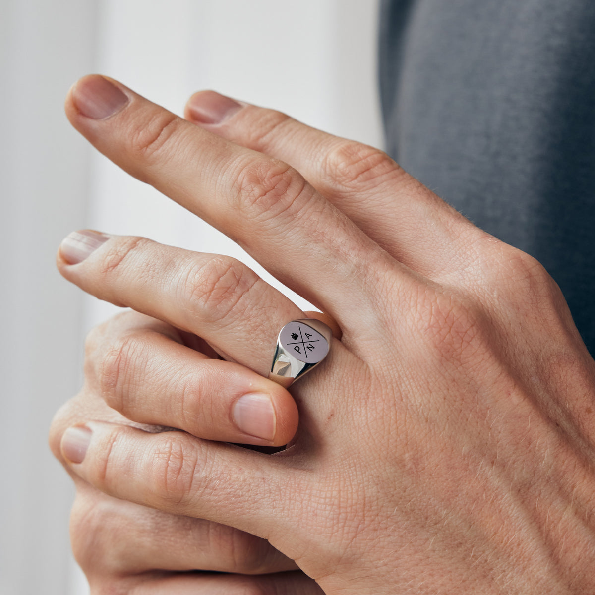 Klassischer Herren-Siegelring mit Gravur in Silber am Finger getragen – Quadranten-Design