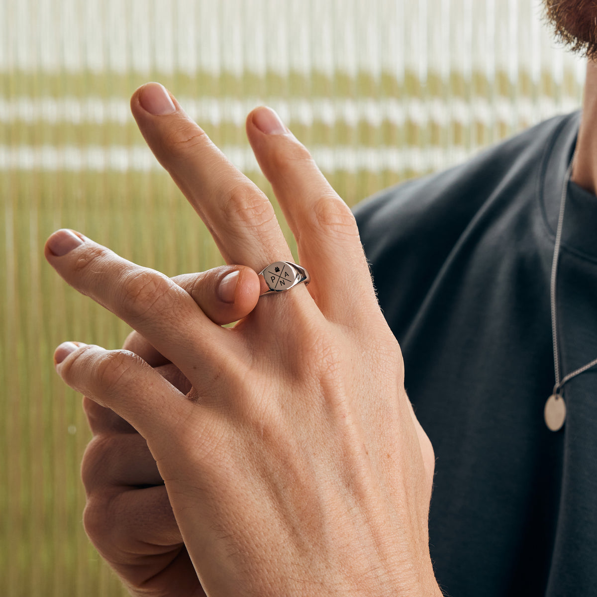 Runder Siegelring mit Gravur in Silber am Finger getragen – Quadranten-Design mit Herzsymbol