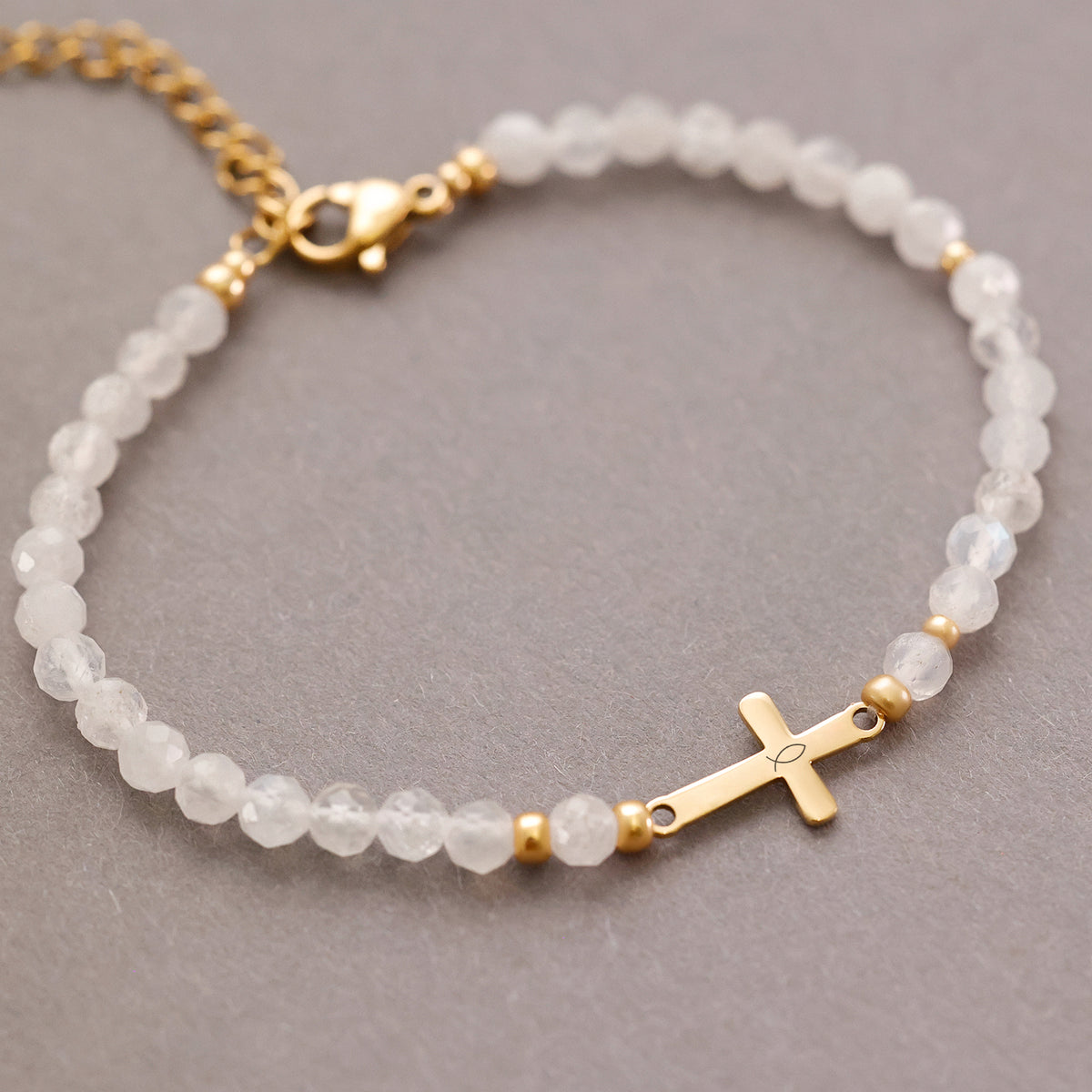 Mondstein Kreuz Armband in Gold, Flat-Lay mit Verschluss und Fischsymbol-Kreuz