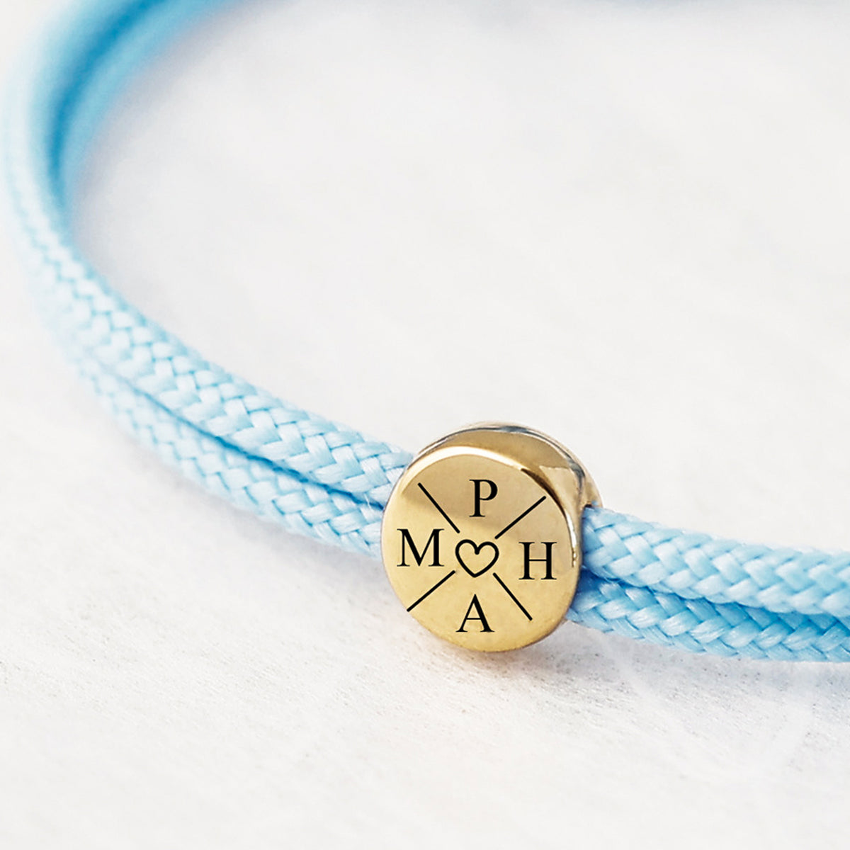 Familienarmband aus Segeltau in Hellblau – Detailansicht der goldenen Gravurplatte mit Initialen und Herz