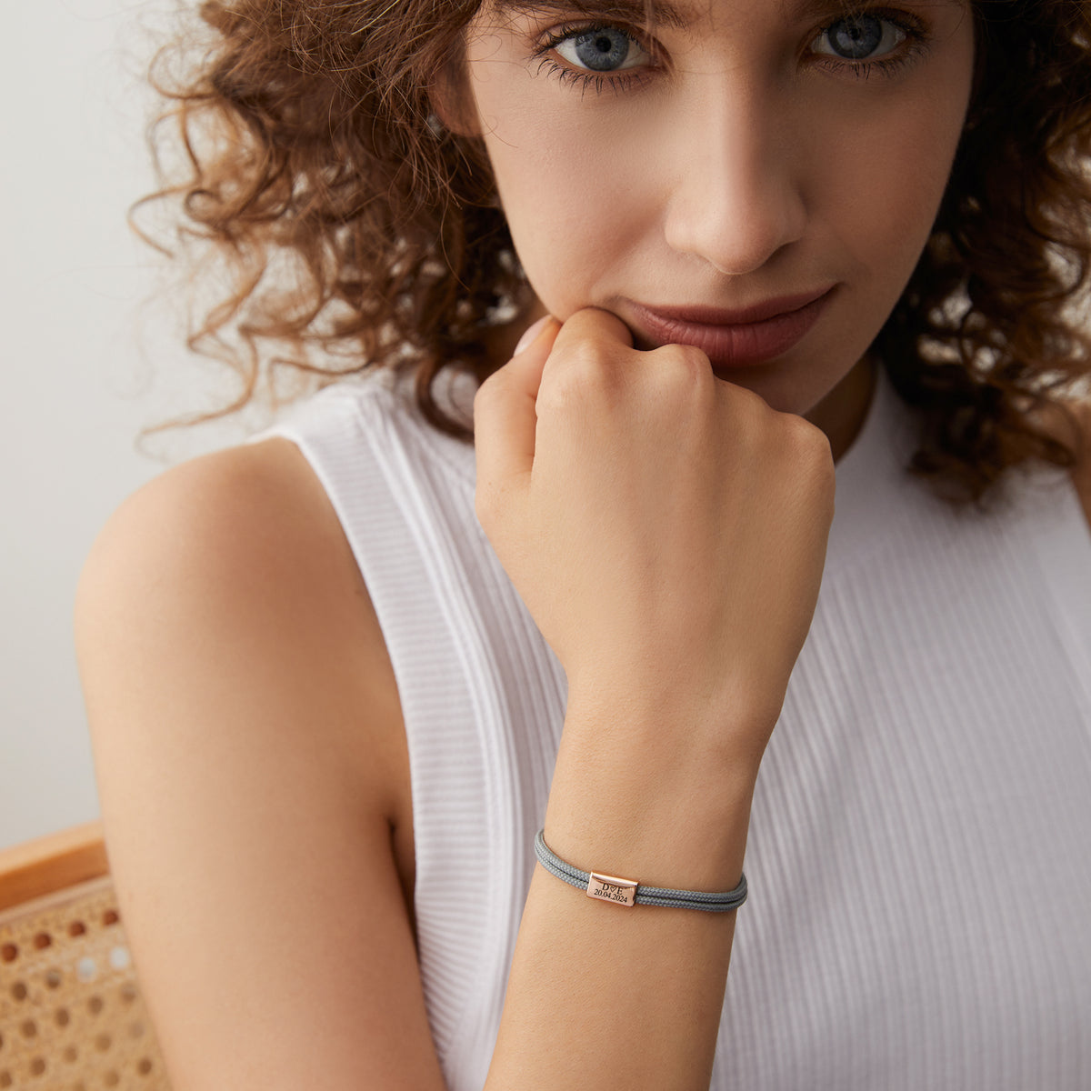 Frau trägt zartes Segeltau-Armband mit personalisierter Gravurperle in Grau am Handgelenk