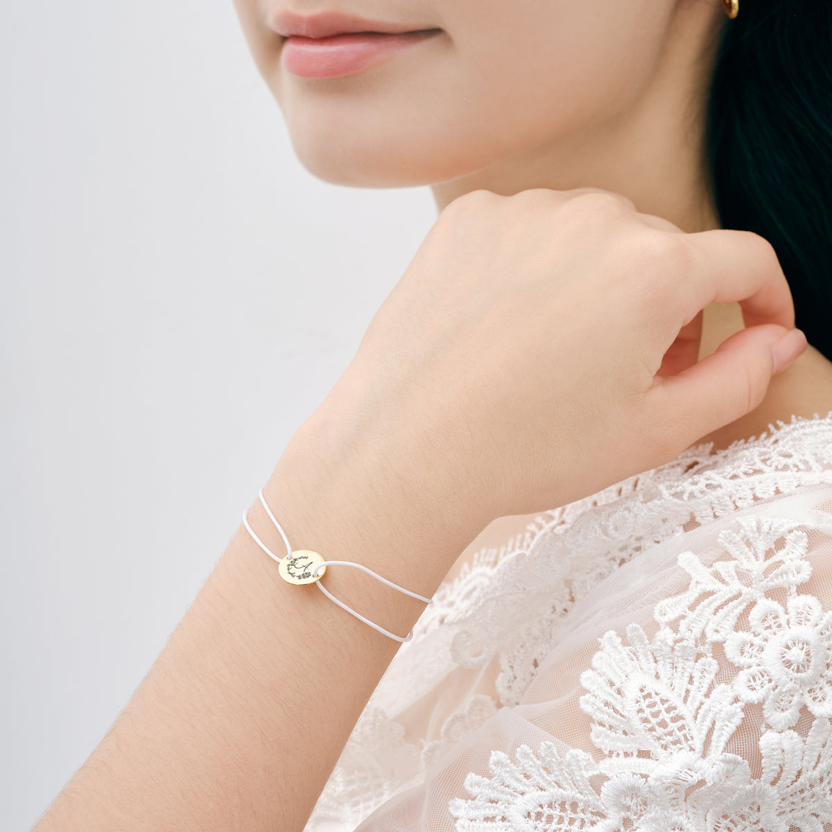 Frau trägt Nylon Unisex Armband mit Gravur am Handgelenk zu weißem Spitzenkleid