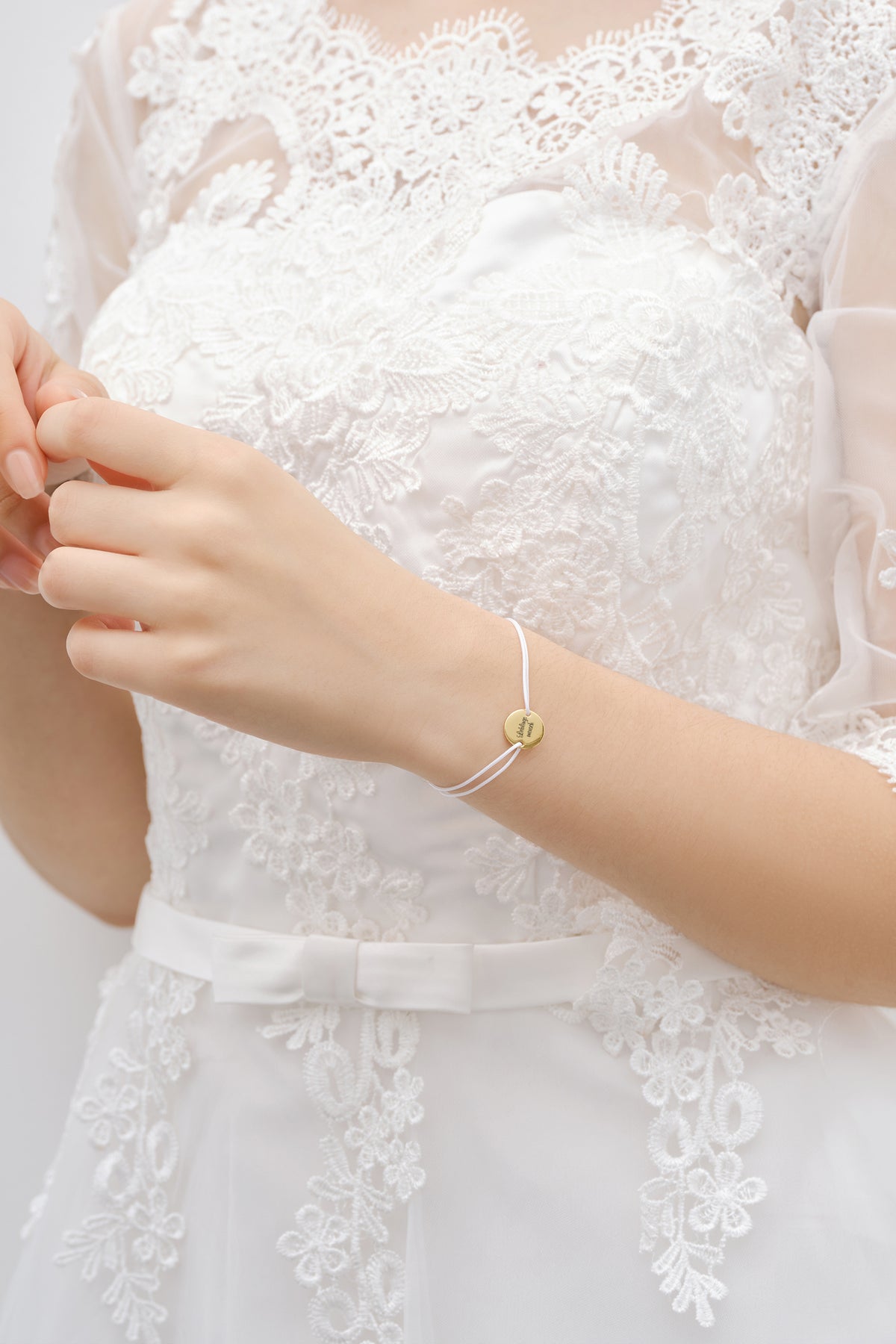 Braut trägt Nylon Unisex Armband mit Gravur am Handgelenk, Kleid mit Schleifengürtel