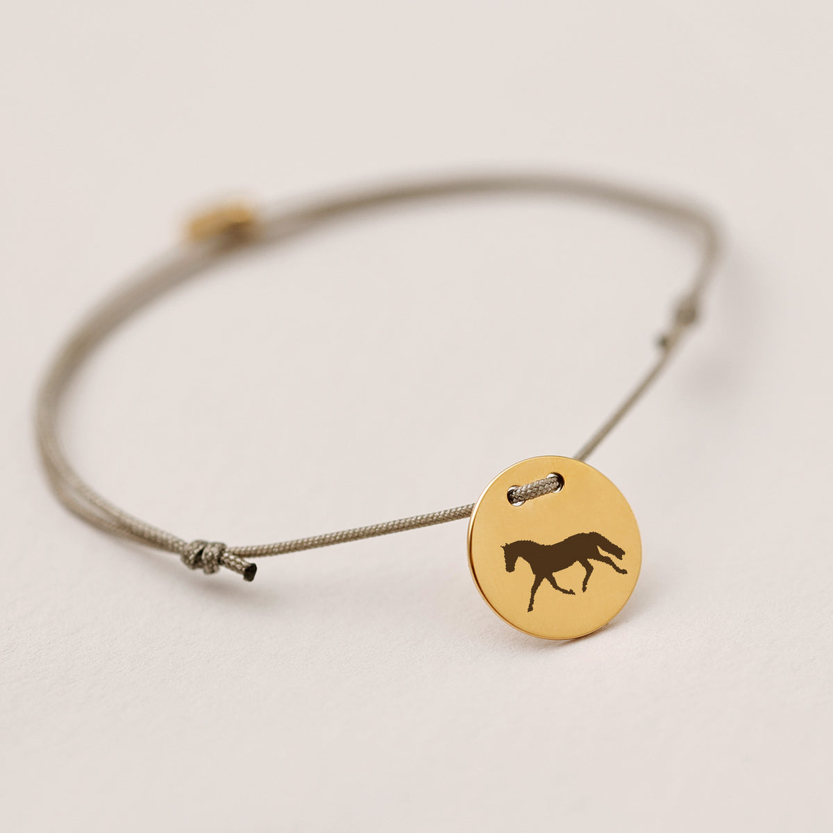Unisex Armband mit Gravur, graue Kordel mit goldenem Plättchen und Pferd-Symbol