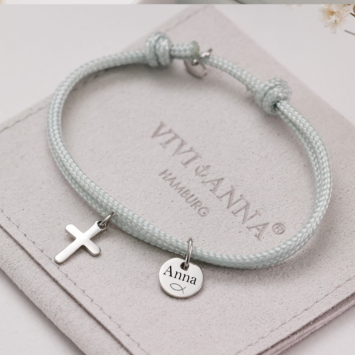 Kreuz-Armband mit personalisiertem Plättchen in Mint auf Beutel, graviertes Plättchen mit Name Anna