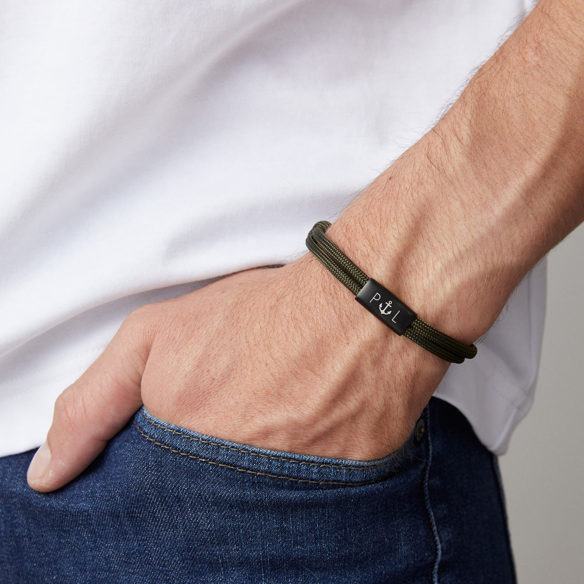 Mann trägt personalisiertes Segeltau Armband in Oliv mit Anker-Symbol und Initialen am Handgelenk