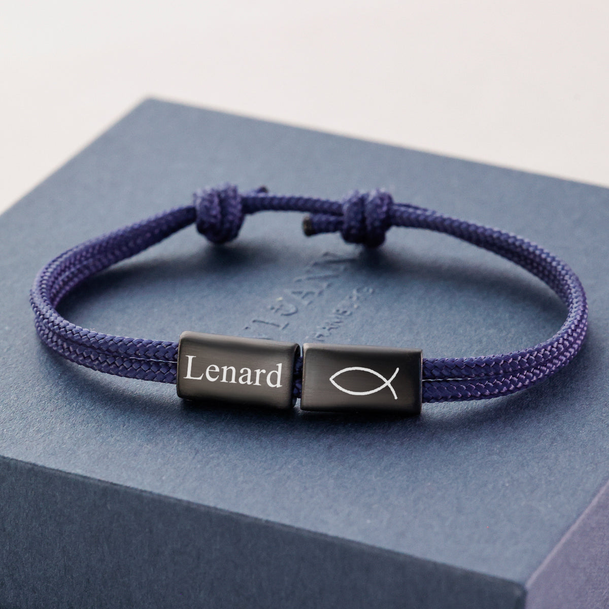 Segeltau Armband mit Wunschgravur in Blau, Plättchen mit Namen und Fisch-Symbol auf Geschenkbox