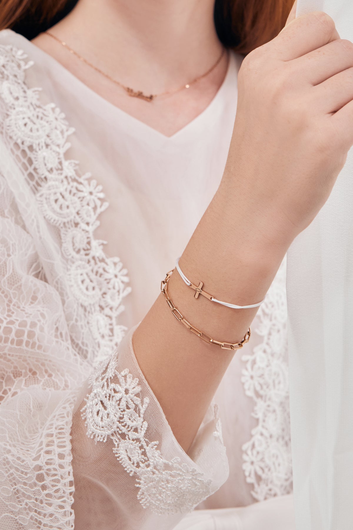 Personalisiertes Kreuzarmband mit Gravur – Mädchen trägt Armband und passende Kette im Spitzenkleid