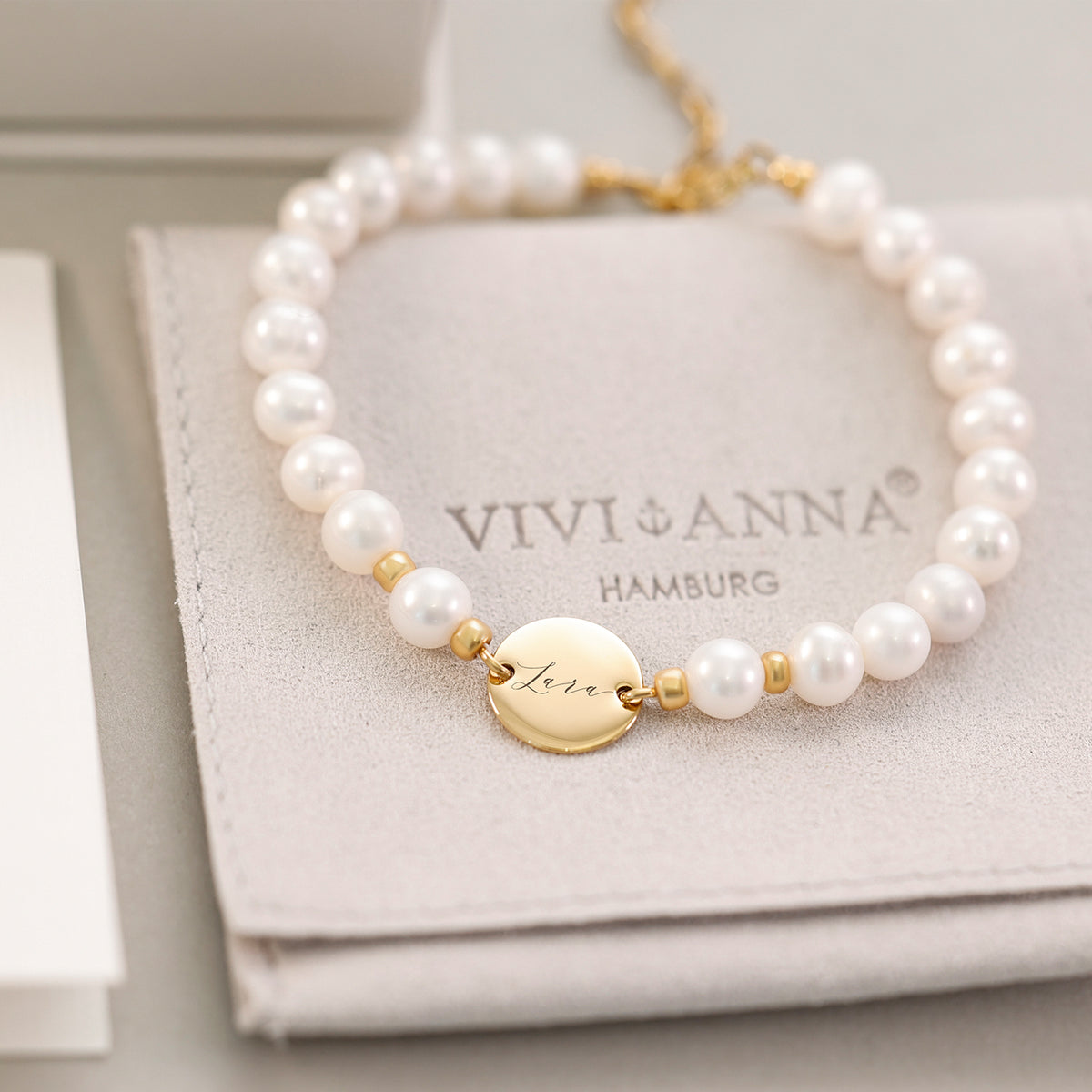 Süßwasserperlen-Armband in Gold mit rundem Plättchen 'Lina' auf VIVI&ANNA-Verpackung