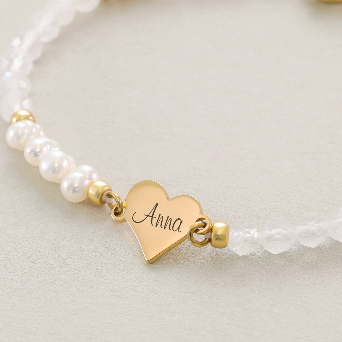 Süßwasserperlen & Mondstein Herz-Armband – Nahaufnahme des goldenen Herzanhängers mit Gravur 'Anna'
