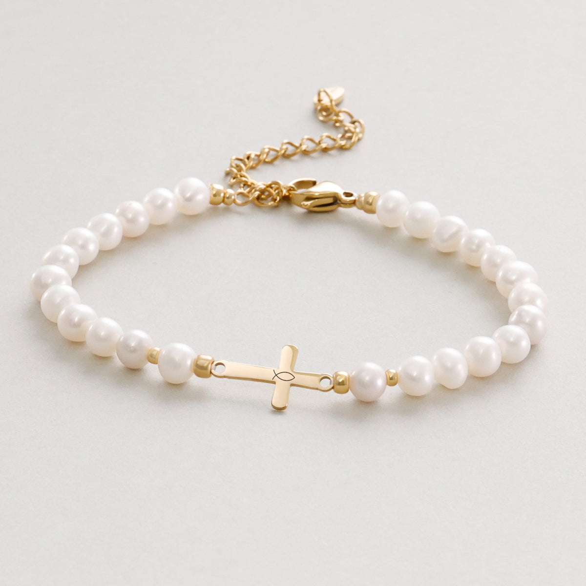 Armband mit Süßwasserperlen und Kreuz in Gold, graviert mit Fisch-Symbol, Nahaufnahme