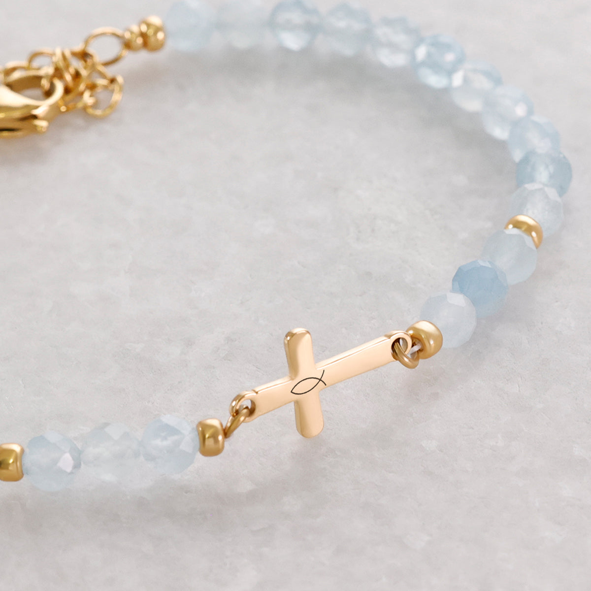 Aquamarin Kreuz Armband zur Kommunion – Detailaufnahme des Kreuzanhängers mit Fischsymbol