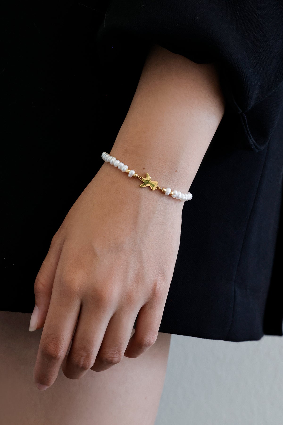 Schutzarmband mit Schutzengel-Anhänger in Gold – Nahaufnahme am Handgelenk