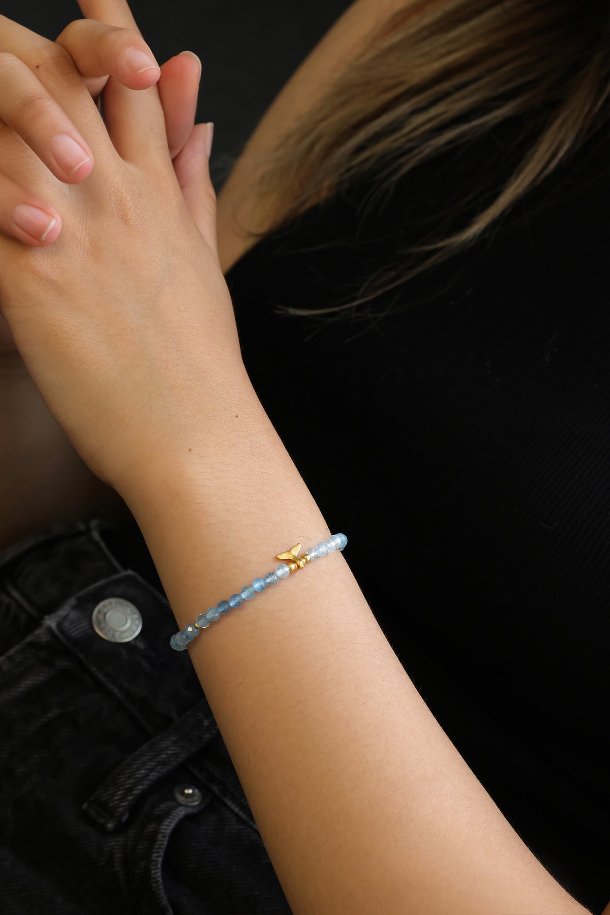 Aquamarin Armband am Handgelenk einer Frau mit gefalteten Händen