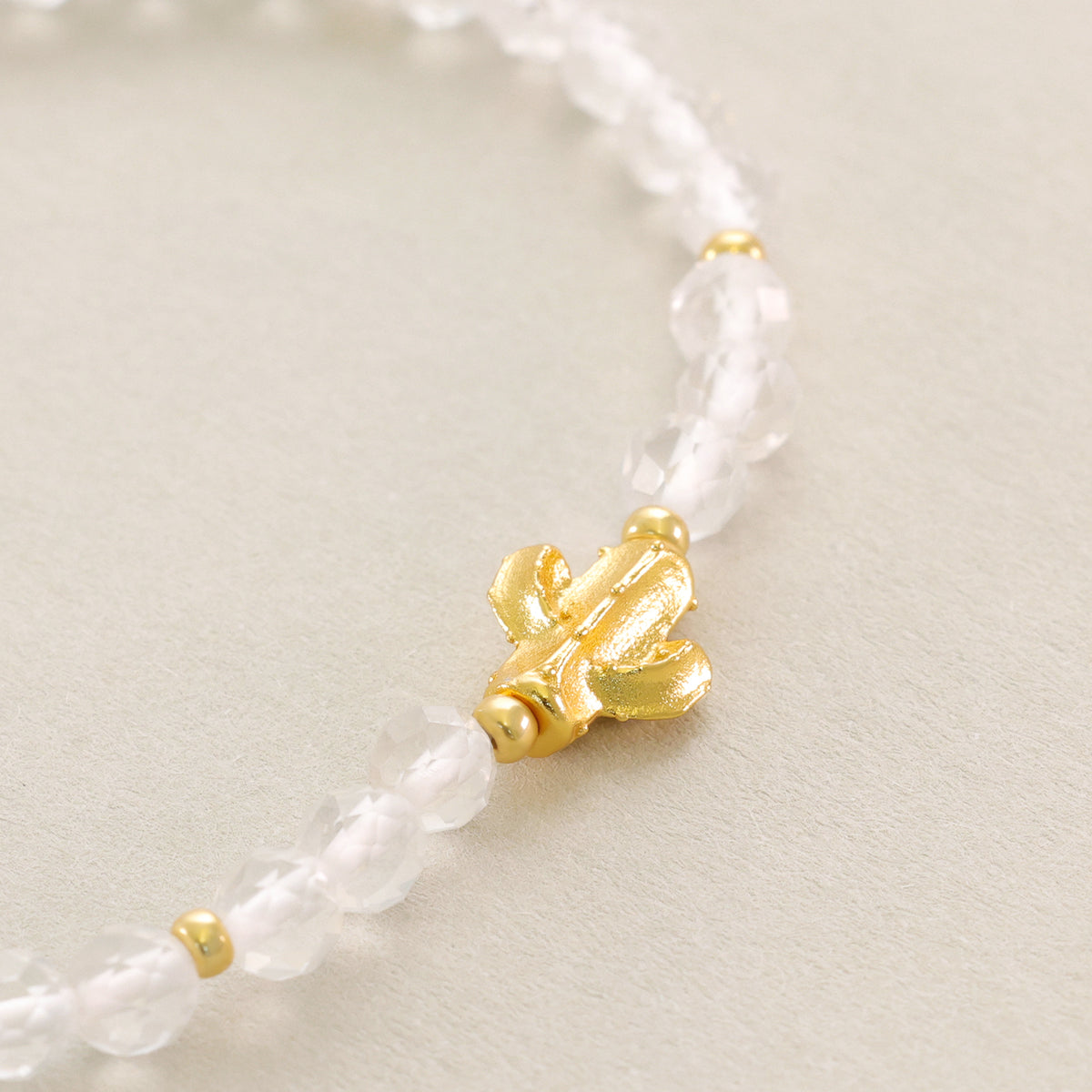 Nahaufnahme des goldenen Kaktus-Anhängers am Bergkristall Armband