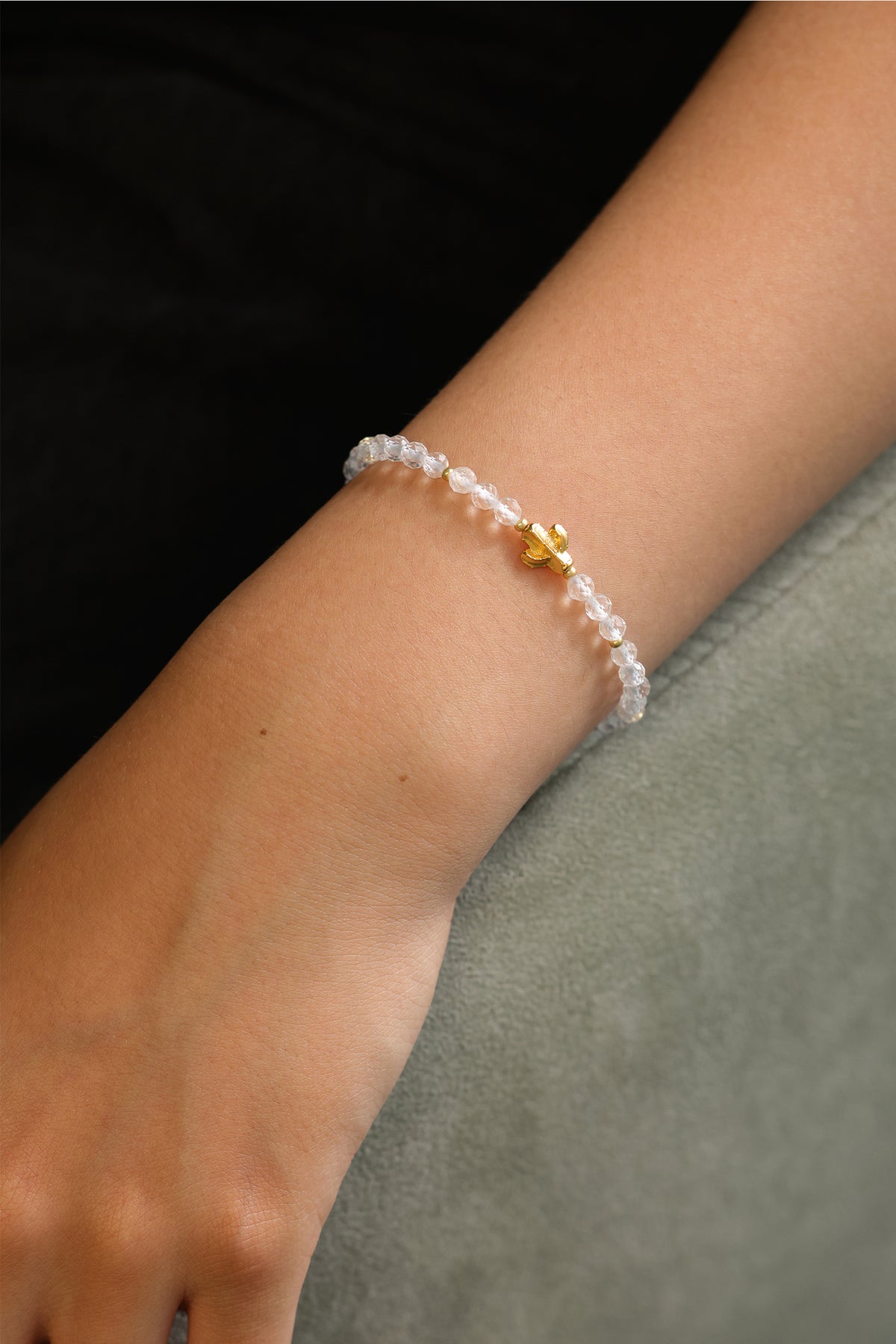 Frau trägt Bergkristall Armband mit Kaktus-Anhänger, Styling-Aufnahme am Arm