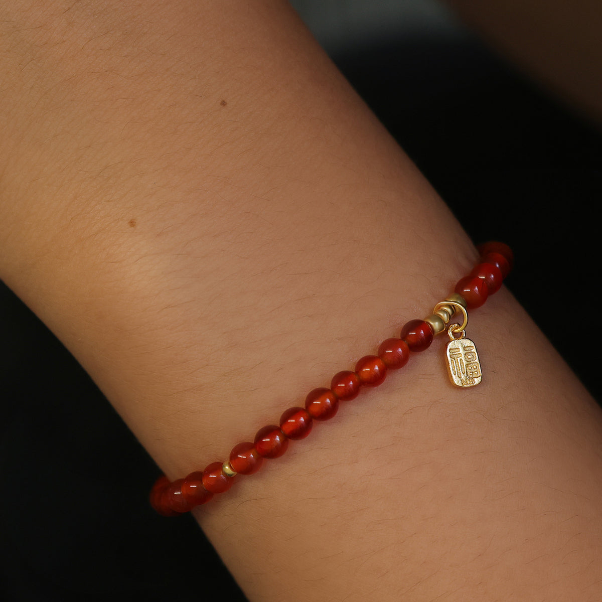 Karneol Armband am Handgelenk, Nahaufnahme mit rotem Perlenverlauf