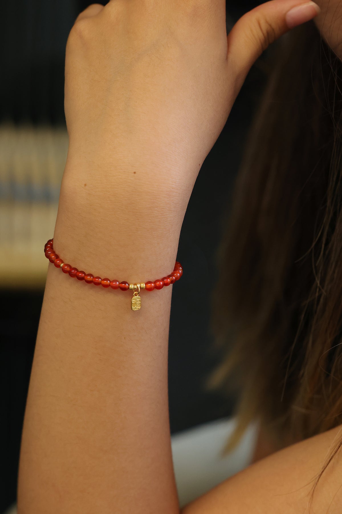 Frau trägt Karneol Armband mit „福“-Anhänger, Styling-Aufnahme am Arm