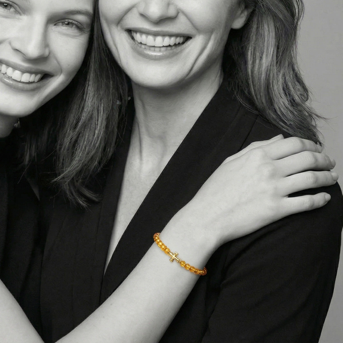Bernstein Armband mit goldenem Kreuz – 925 Sterling Silber, Schwarz-Weiß-Porträt, eine Frau trägt das Armband
