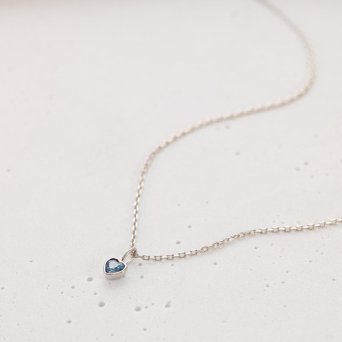 Silberne Kette mit herzförmigem Geburtsstein-Anhänger in Blau, Nahaufnahme