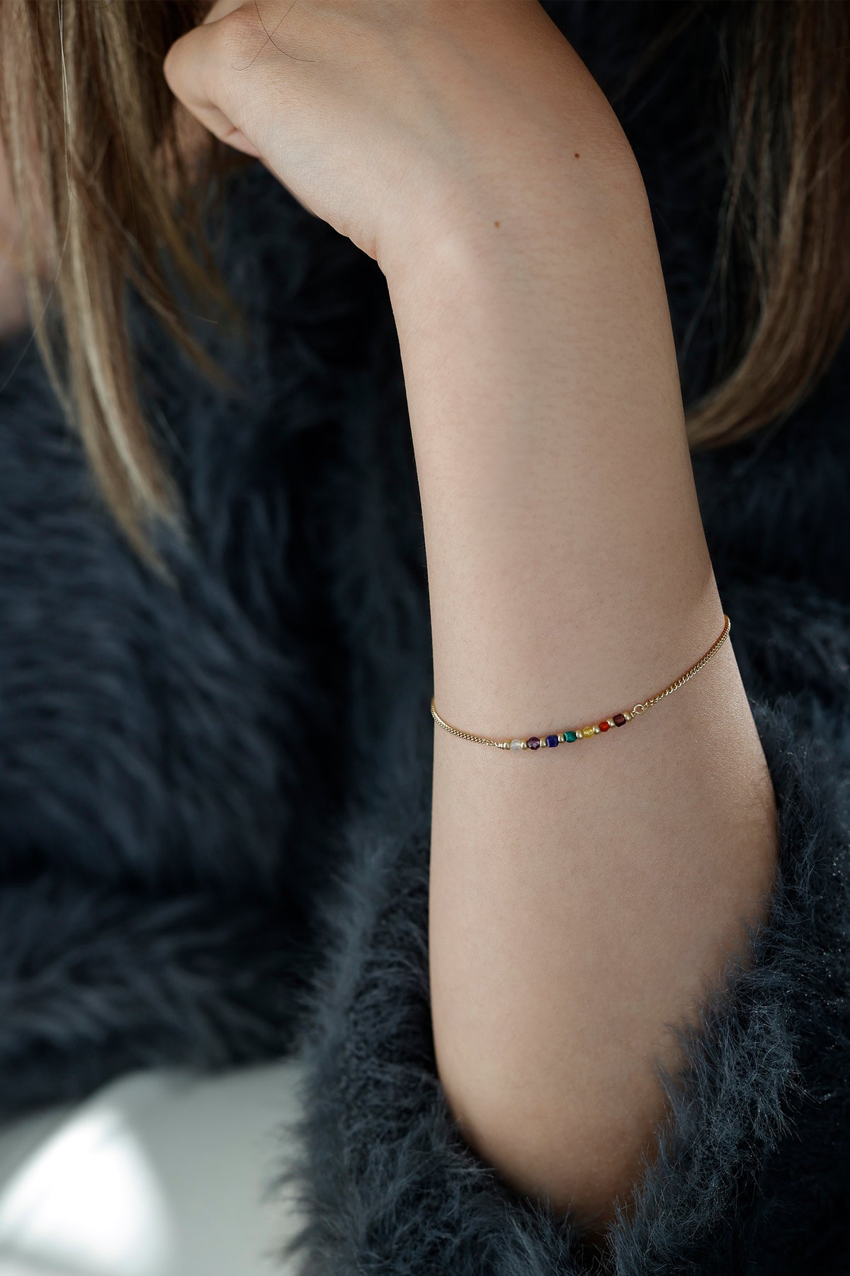 Frau trägt Chakra Armband in Gold am erhobenen Arm