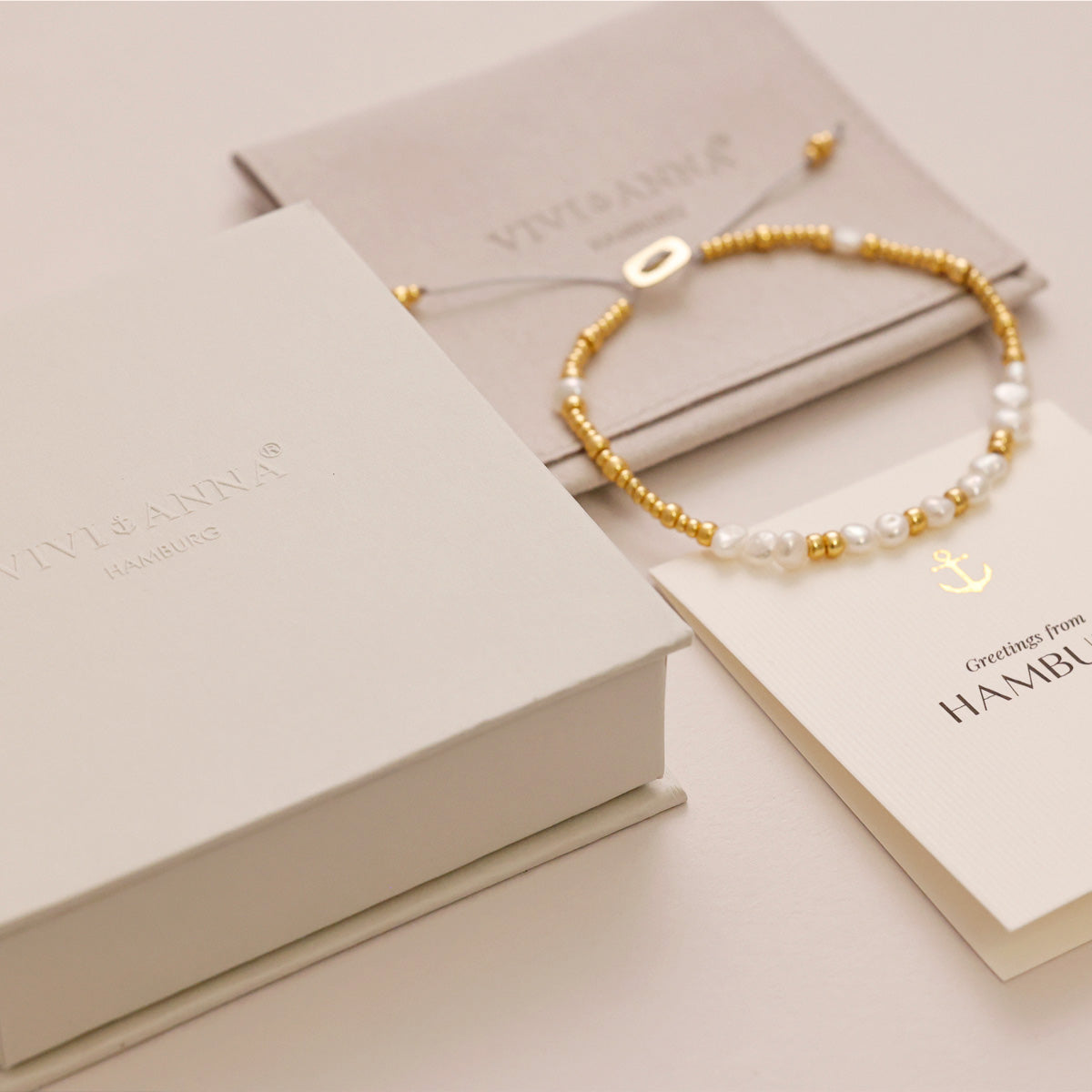 Damen-Geschenkverpackung in Beige mit Karte und Armband aus Gold- und Perlenelementen