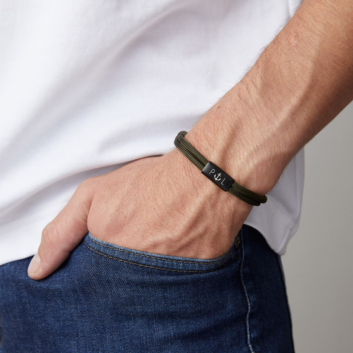 Mann trägt personalisiertes Segeltau Armband in Dunkelblau mit Anker-Symbol und Initialen am Handgelenk