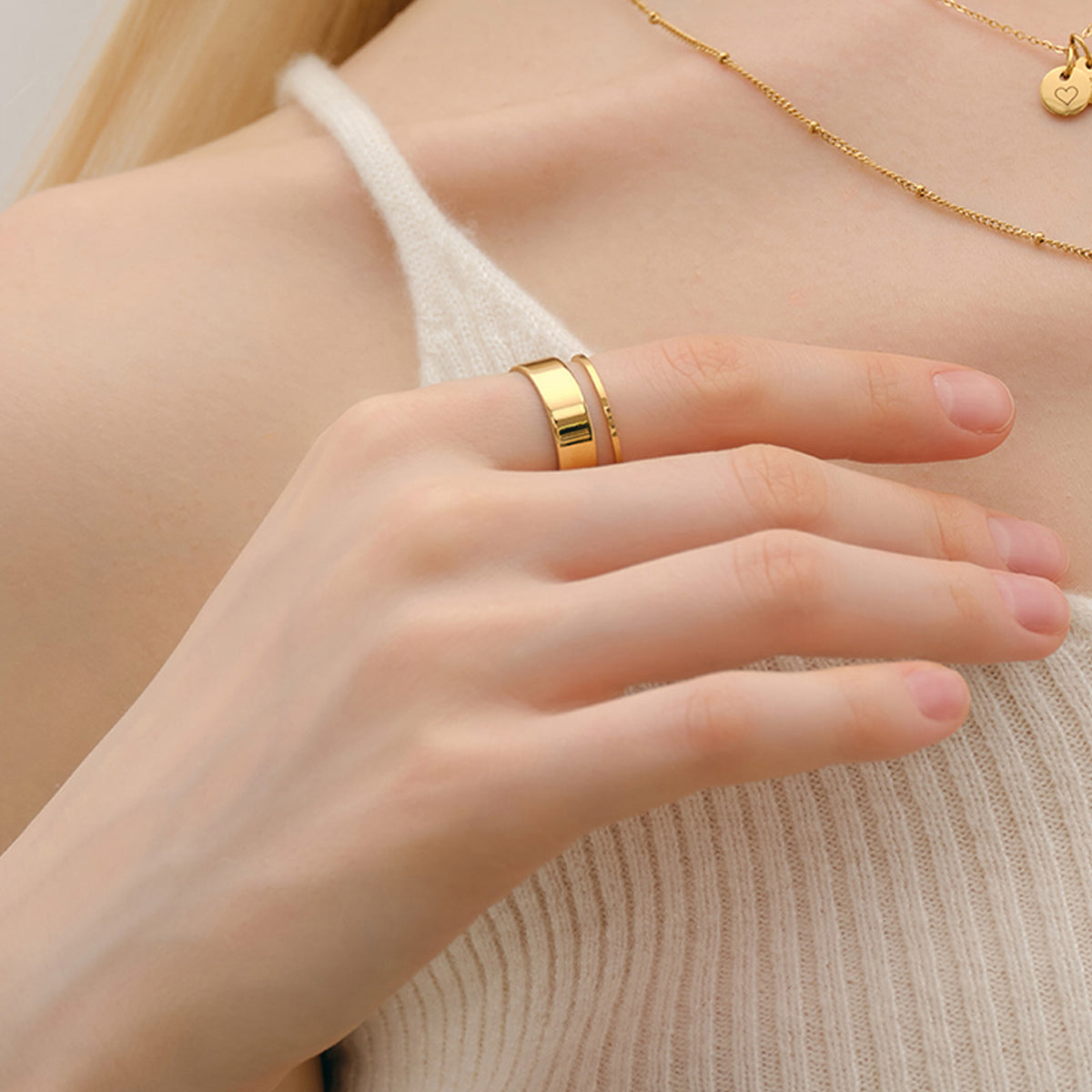 Feiner Stapelring in Gold – Frau trägt zwei Ringe gestapelt am Finger, Nahaufnahme