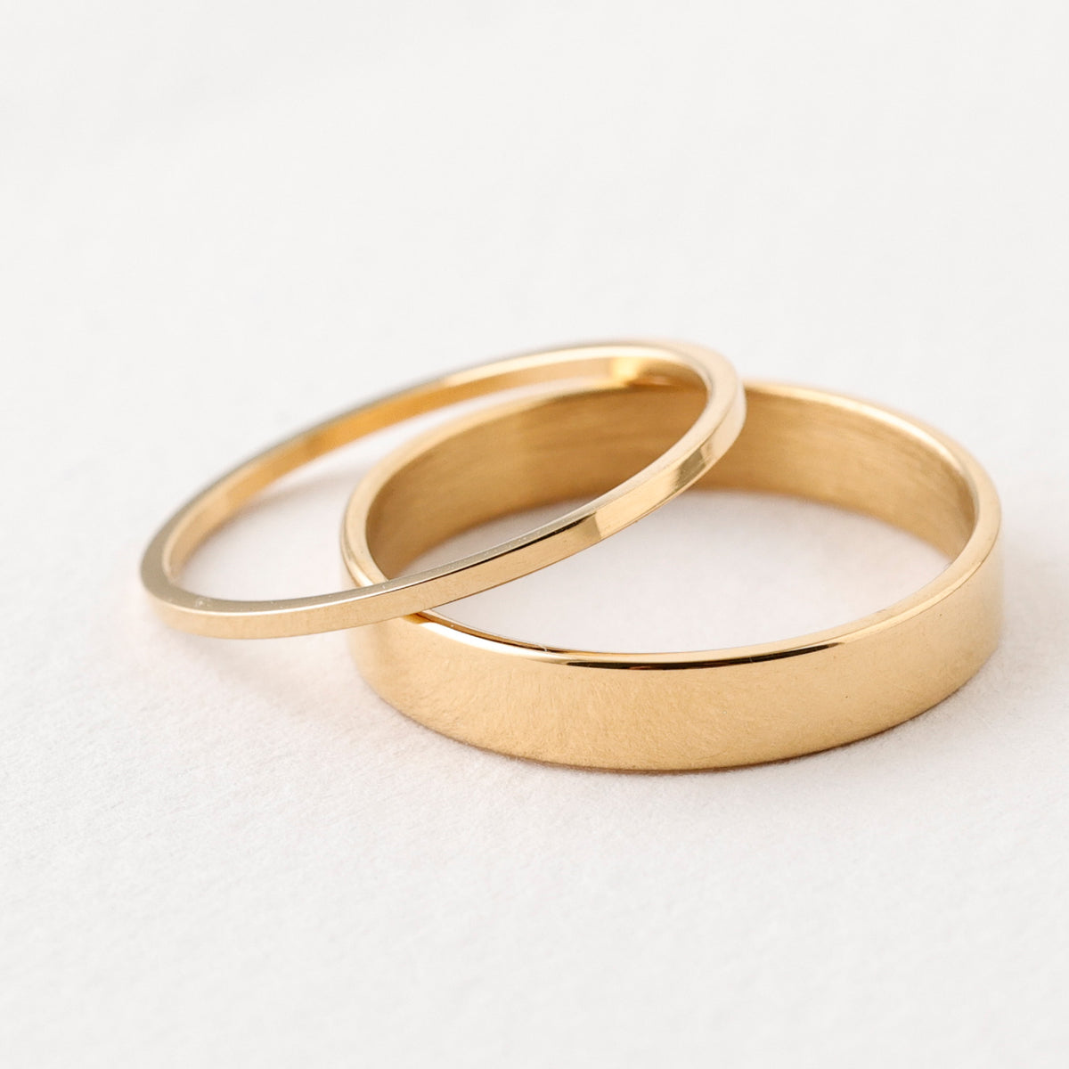 Feiner Stapelring in Gold – schmaler Ring neben breiterem Bandring im Vergleich