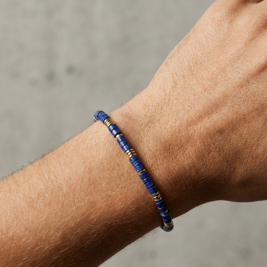 Edelsteinarmband mit Lapislazuli und Hämatit am Handgelenk getragen, Nahaufnahme der blauen Perlen