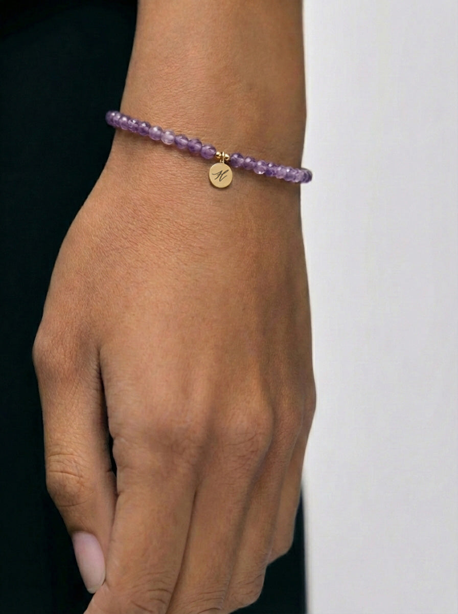 Frau trägt Amethyst-Armband mit graviertem Anhänger am Handgelenk