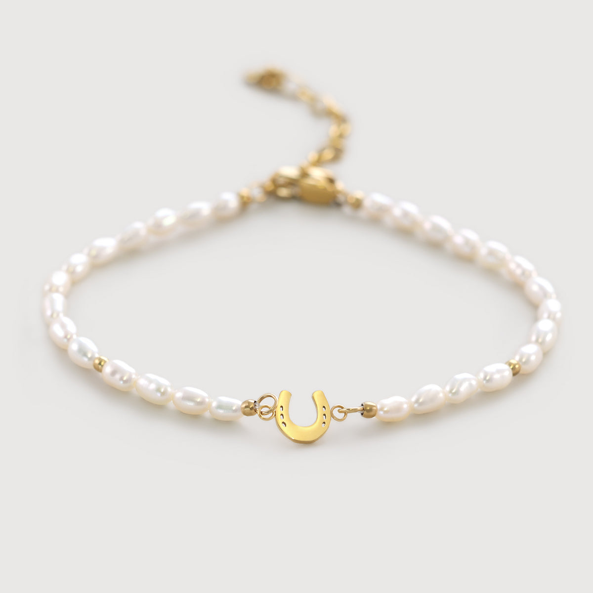 Hufeisen Perlenarmband, Süßwasserperlen mit goldenem Hufeisen-Anhänger, flach ausgelegt