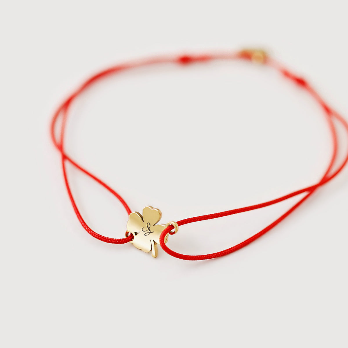 Personalisiertes Glücksbringer Armband mit Kleeblatt in Gold, rotes Band mit graviertem Buchstaben