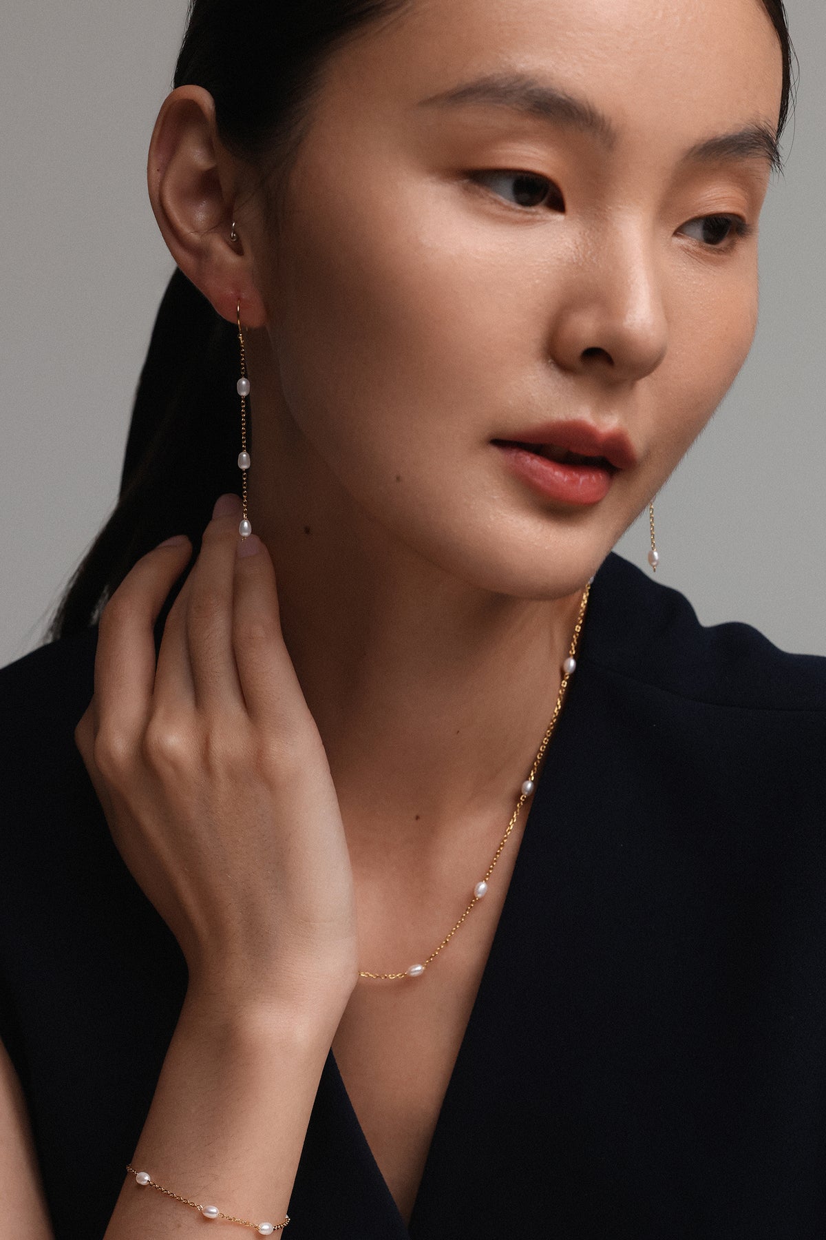 Ohrringe mit Süßwasserperlen - 925er Sterlingsilber, Frau trägt Ohrringe kombiniert mit Kette und Armband