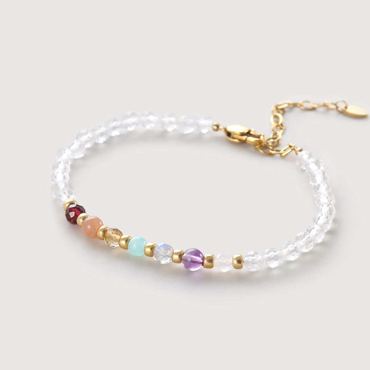 Bergkristall-Armband mit bunten Chakra-Steinen in der Mitte, klare Perlen außenrum