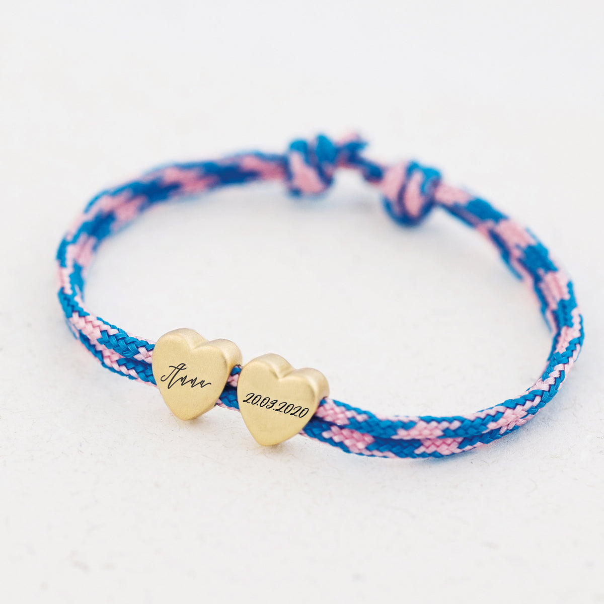 Herzarmband aus Segeltau in Blau-Rosa mit zwei goldenen Herzen – Name und Datum '20.03.2020' graviert