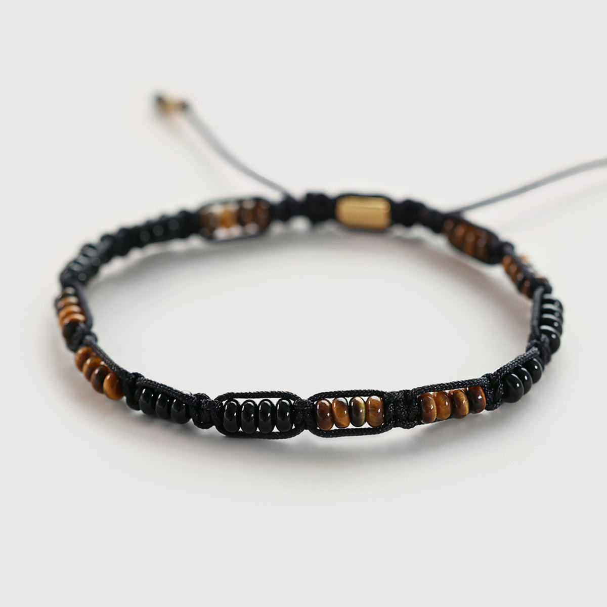Makramee Armband mit Tigerauge- und Onyx-Perlen, flach liegend fotografiert