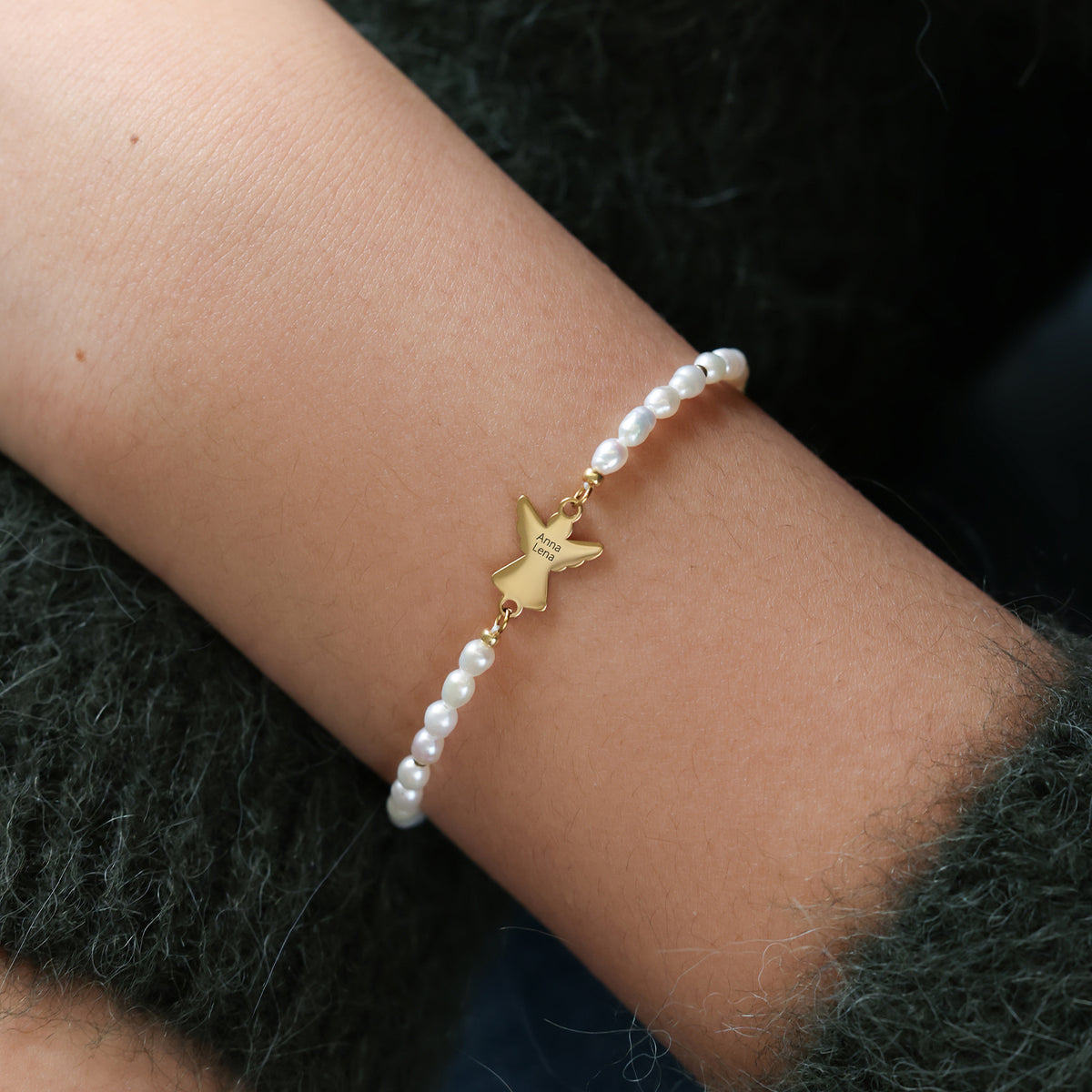 Nahaufnahme: Schutzengel-Perlenarmband am Handgelenk, graviert mit dem Namen Anna Lena