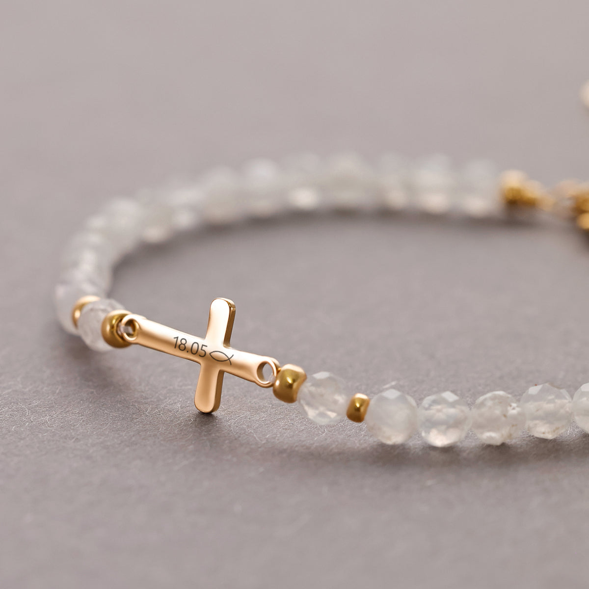 Mondstein-Armband mit goldenem Kreuzsteg und Gravur '18.05' mit kleinem Fischsymbol