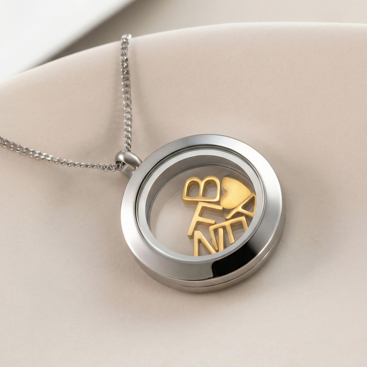 Glasmedaillon-Kette mit Wunschbuchstaben liegend, drei goldene Buchstaben und Herz im Medaillon